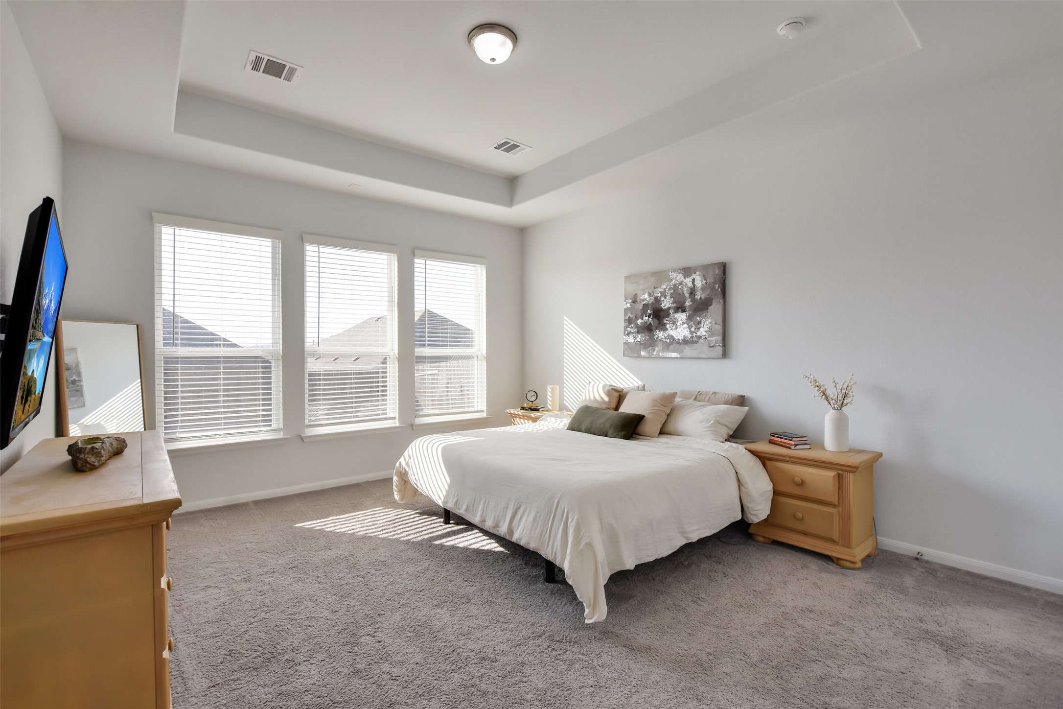 605 Oleander Loop Buda, TX 78610 - Photo 15 of 32 a bedroom with a bed a large window and a flat tv screen on dresser