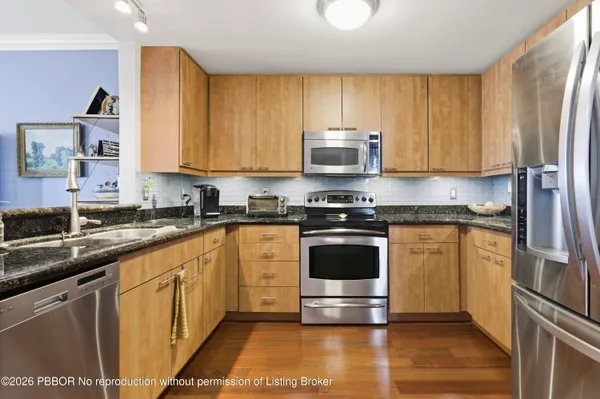 a kitchen with stainless steel appliances a stove a sink and a refrigerator
