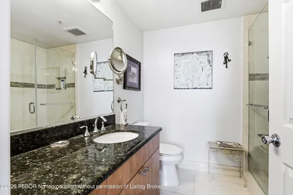 a bathroom with a granite countertop sink toilet and a mirror