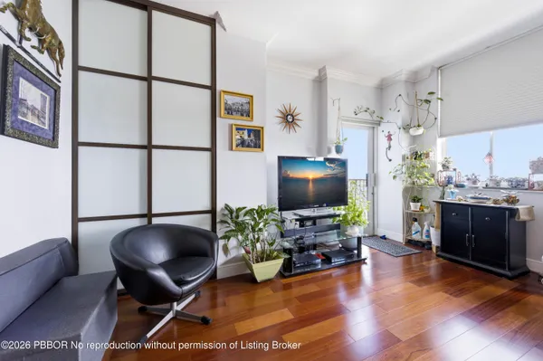 a living room with furniture hard wood floor and a flat screen tv