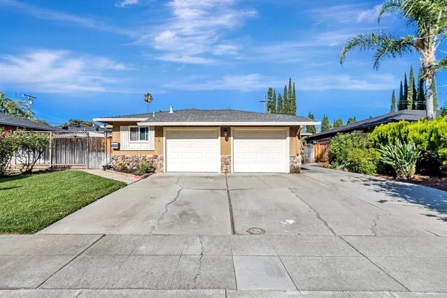 a view of a house with a yard and potted plants