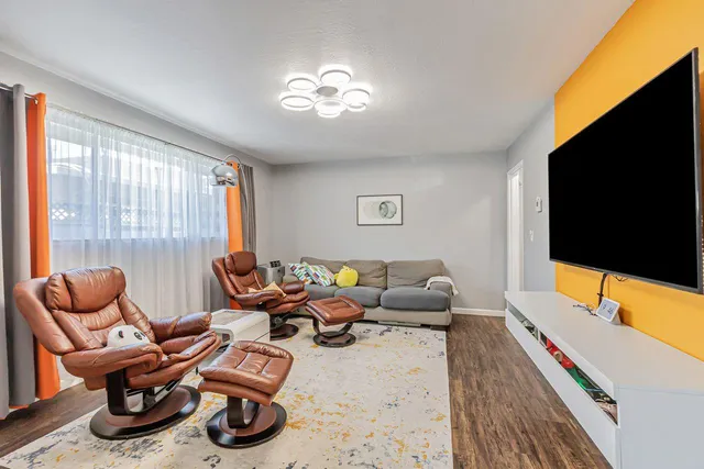 a living room with furniture flat screen tv and windows