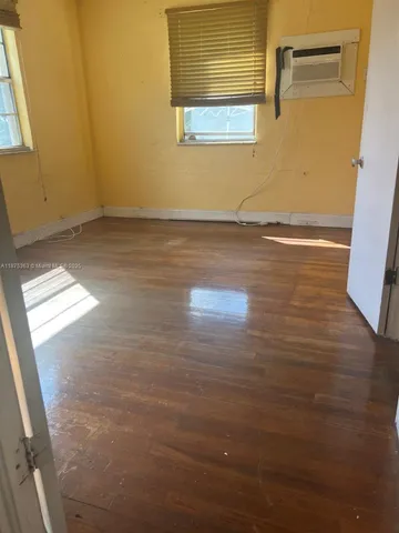 a view of a room with wooden floor and white wall