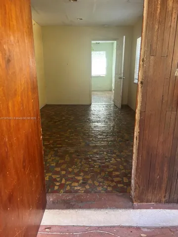 a view of a room with wooden floor and window