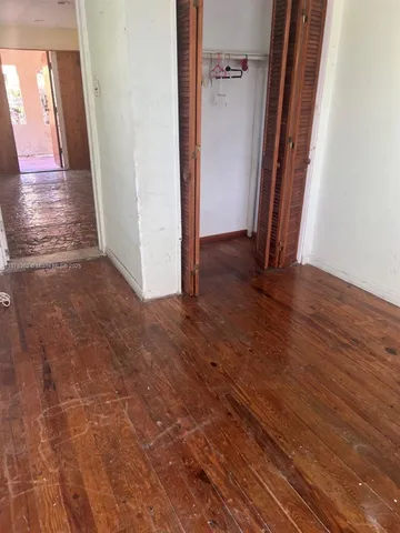 a view of an empty room and wooden floor