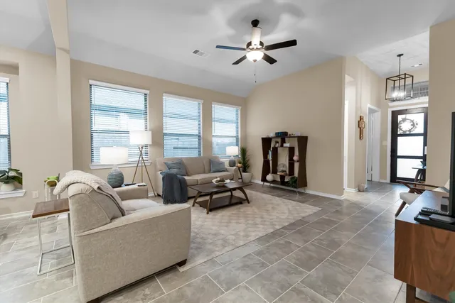 a living room with furniture and hard wood flooring
