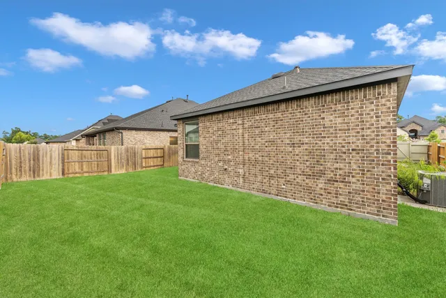 a view of a backyard with brick wall and wooden fence