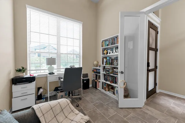 a view of a workspace with furniture and a window