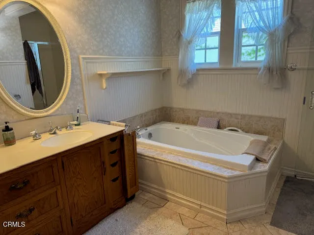 a bathroom with a tub sink and mirror