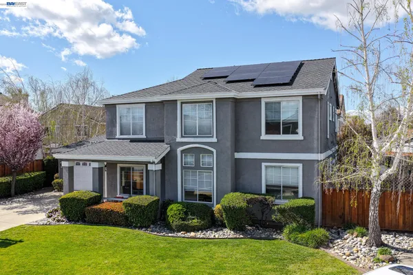 a front view of a house with yard and green space