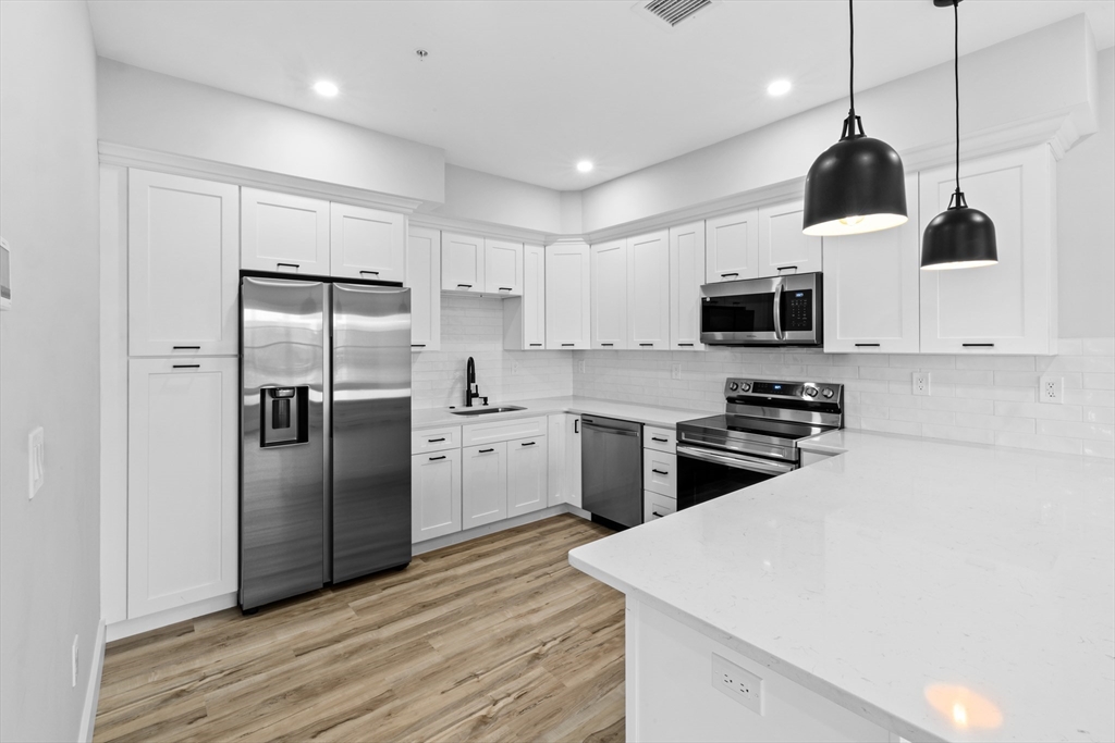889-895 Grinnell Street, Unit 2 Fall River, MA 02721 - Photo 12 of 42 a kitchen with stainless steel appliances a refrigerator sink and microwave