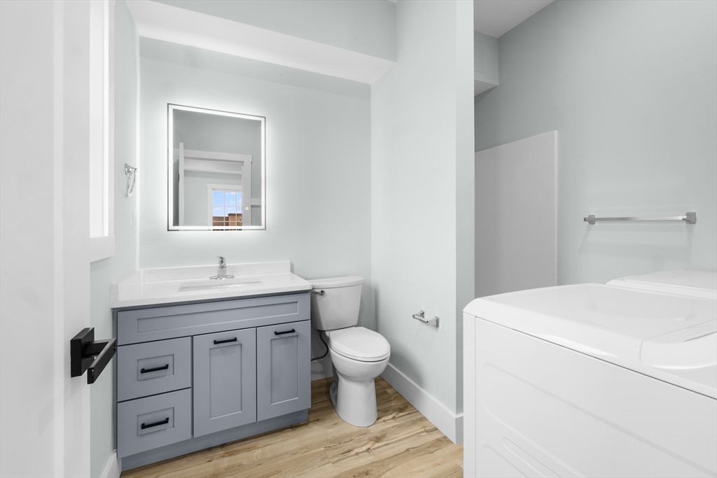 889-895 Grinnell Street, Unit 2 Fall River, MA 02721 - Photo 18 of 42 a bathroom with a granite countertop toilet sink and mirror