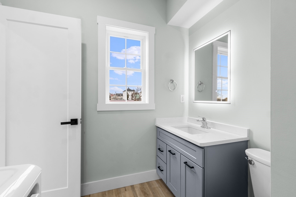 889-895 Grinnell Street, Unit 2 Fall River, MA 02721 - Photo 19 of 42 a bathroom with a sink mirror vanity and toilet