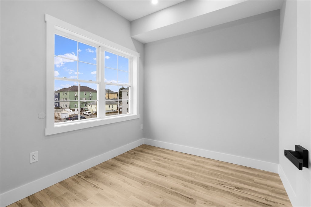 889-895 Grinnell Street, Unit 2 Fall River, MA 02721 - Photo 25 of 42 a view of an empty room with wooden floor and a window