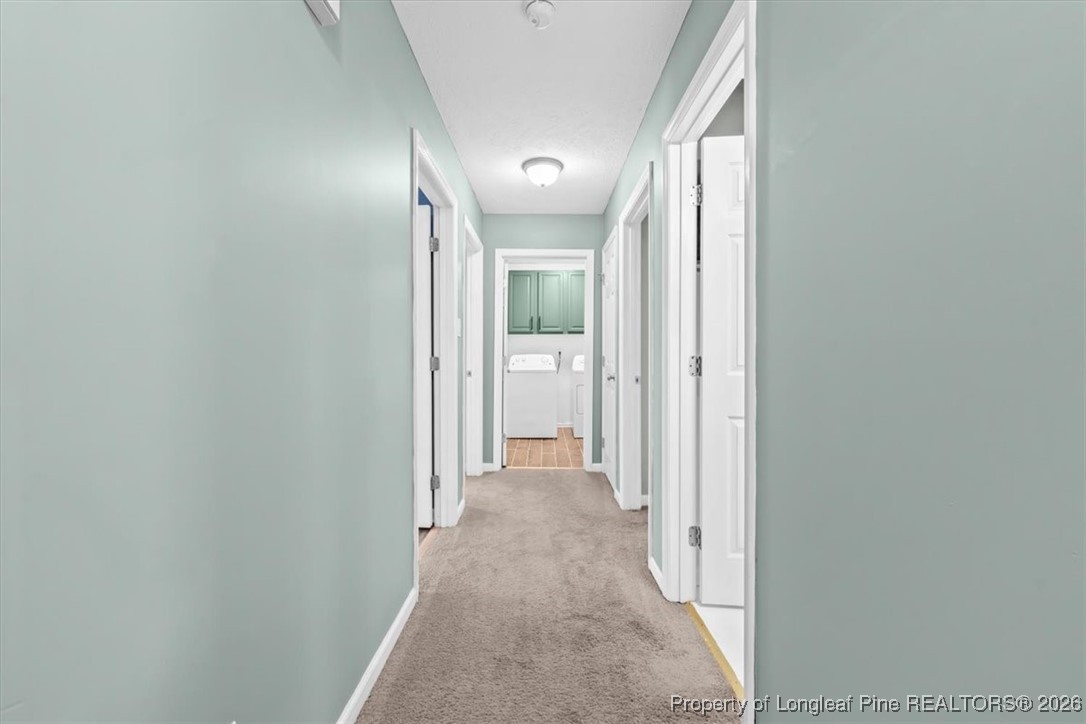 2736 Millmann Road Fayetteville, NC 28304 - Photo 17 of 33 a view of a hallway with wooden floor and a bathroom