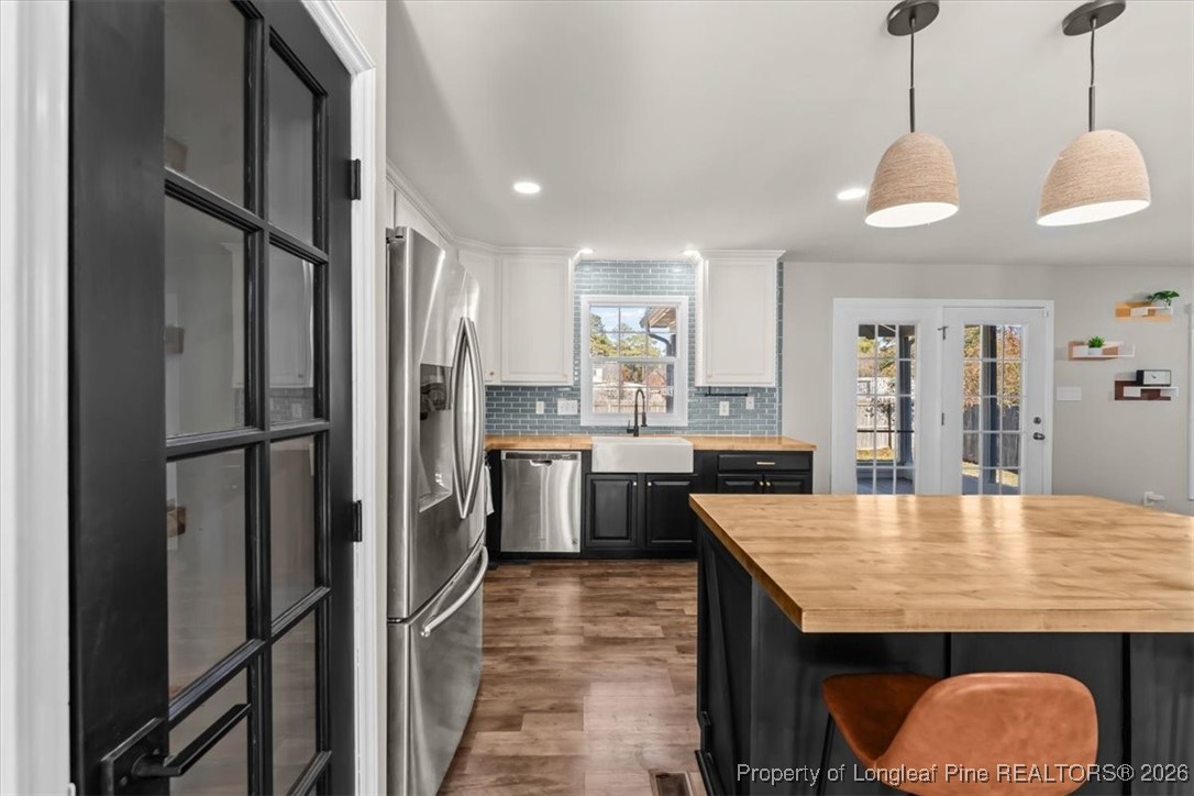2736 Millmann Road Fayetteville, NC 28304 - Photo 8 of 33 a kitchen with stainless steel appliances granite countertop a refrigerator a sink dishwasher a stove and white cabinets with wooden floor