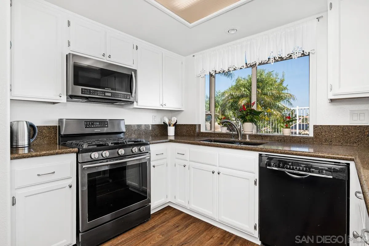 649 Montage Road Oceanside, CA 92057 - Photo 4 of 26 a kitchen with cabinets stainless steel appliances and a sink
