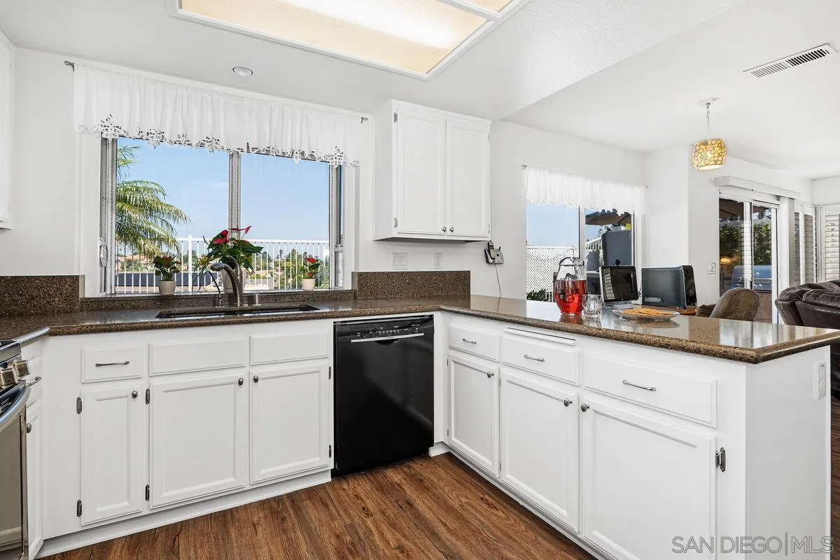 649 Montage Road Oceanside, CA 92057 - Photo 9 of 26 a kitchen with granite countertop white cabinets and white appliances