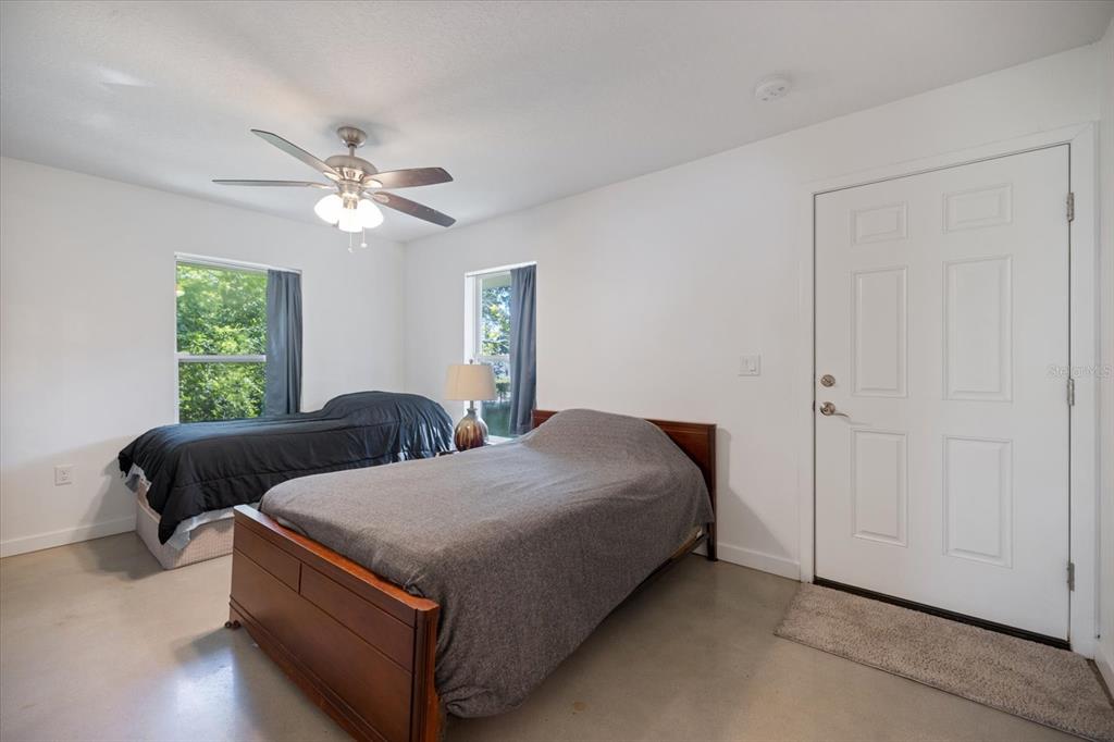 8915 Vamo Road Sarasota, FL 34231 - Photo 37 of 61 a bedroom with two beds and a chandelier