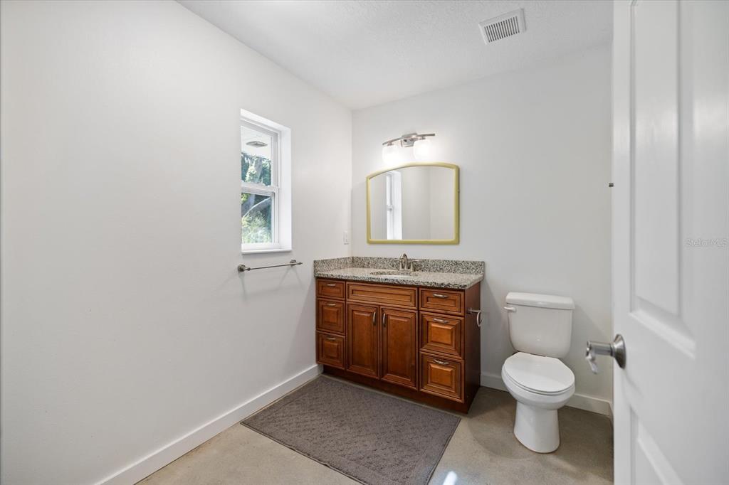 8915 Vamo Road Sarasota, FL 34231 - Photo 40 of 61 a bathroom with a toilet a sink and mirror