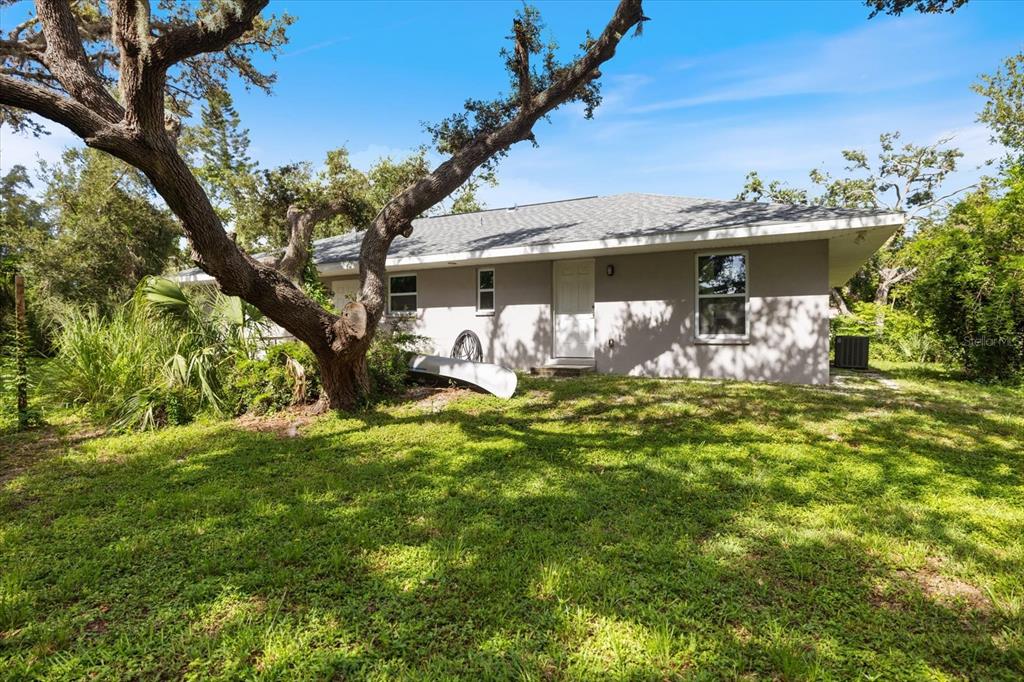 8915 Vamo Road Sarasota, FL 34231 - Photo 52 of 61 a view of a yard with table and chairs under an umbrella