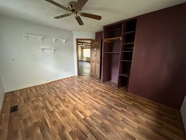 a view of empty room with wooden floor and window