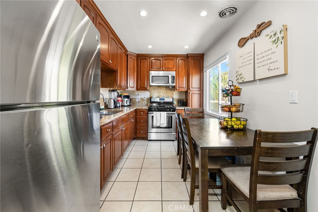 435 East Adams Street Santa Ana, CA 92707 - Photo 9 of 32 a kitchen with stainless steel appliances a refrigerator a sink a stove and white cabinets