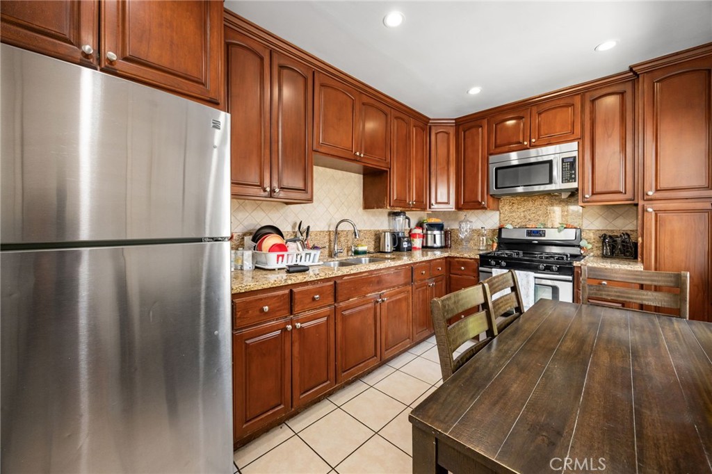 435 East Adams Street Santa Ana, CA 92707 - Photo 10 of 32 a kitchen with stainless steel appliances granite countertop a refrigerator stove top oven and sink