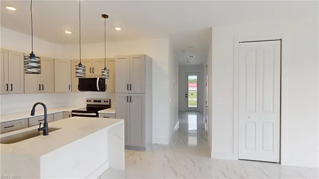 a kitchen with stainless steel appliances a refrigerator a sink a stove and microwave