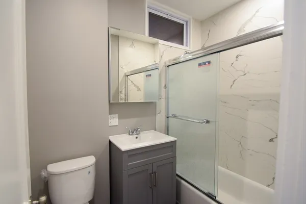 a bathroom with a sink a toilet and shower