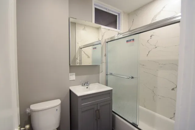 a bathroom with a sink a toilet and shower
