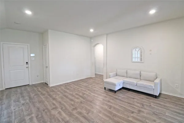 a living room with furniture and a wooden floor