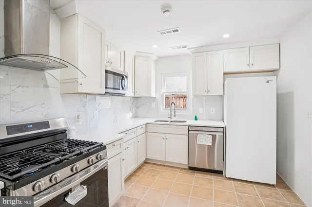 a kitchen with a stove sink and cabinets