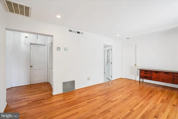 a view of empty room with wooden floor
