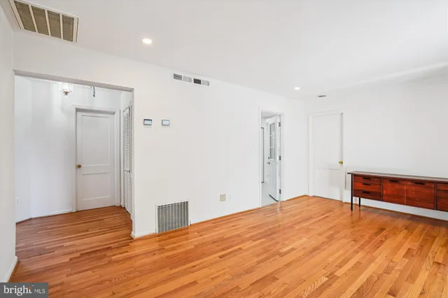 a view of empty room with wooden floor