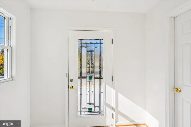 a view of a hallway with wooden floor and entryway