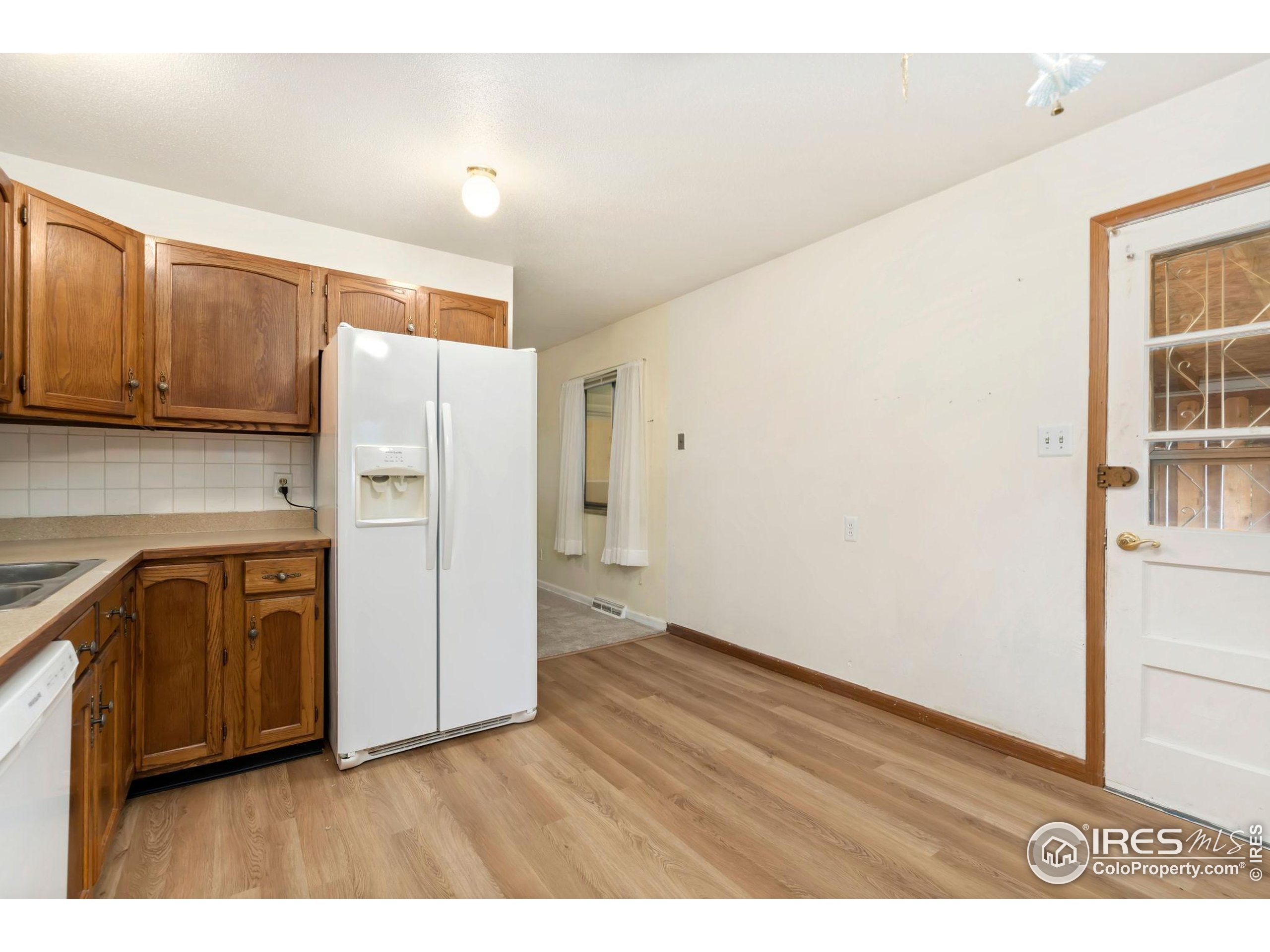 2046 26th Street Road Greeley, CO 80631 - Photo 14 of 34 a kitchen with cabinets and wooden floor