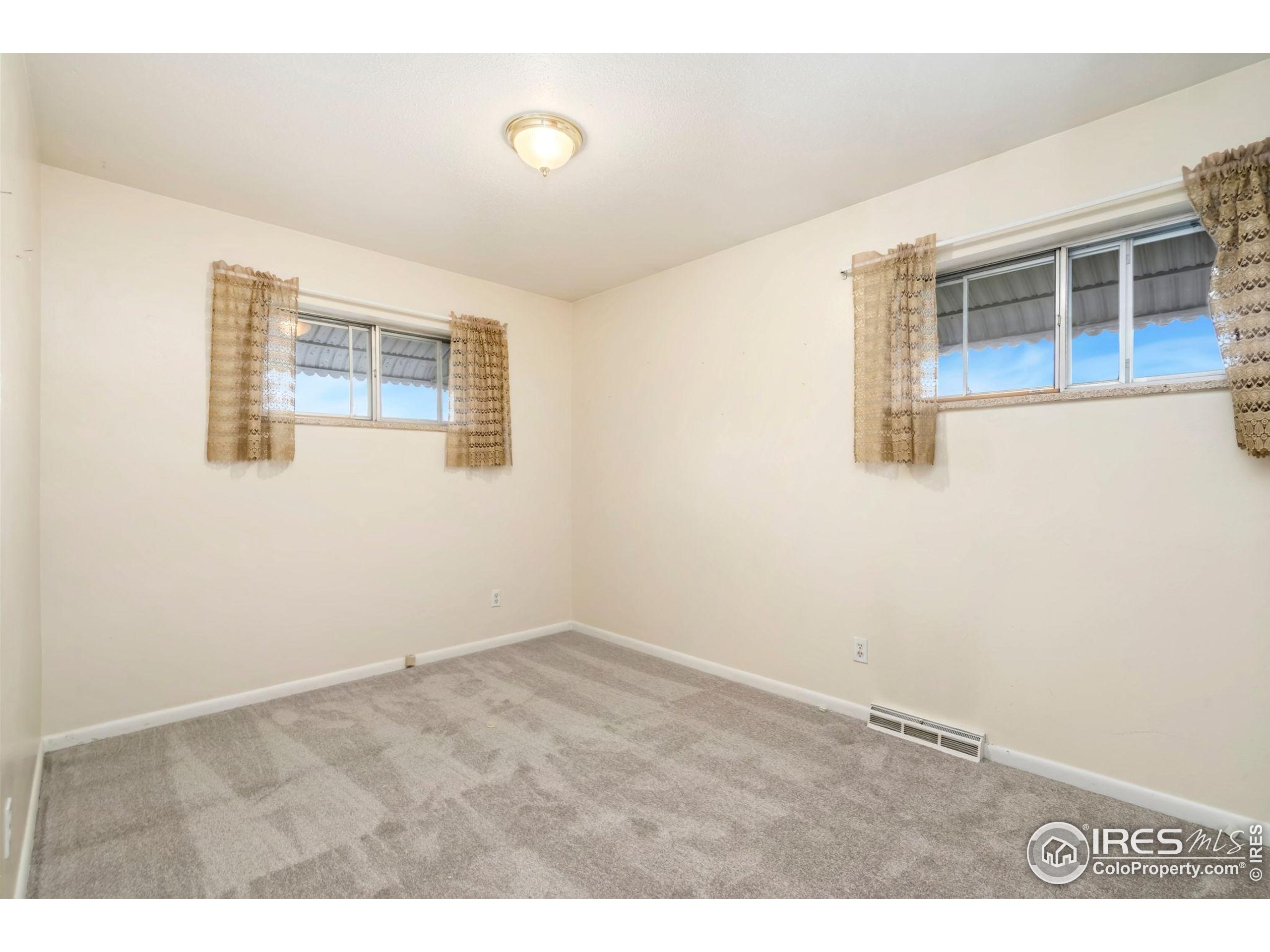 2046 26th Street Road Greeley, CO 80631 - Photo 15 of 34 an empty room with wooden floor and windows