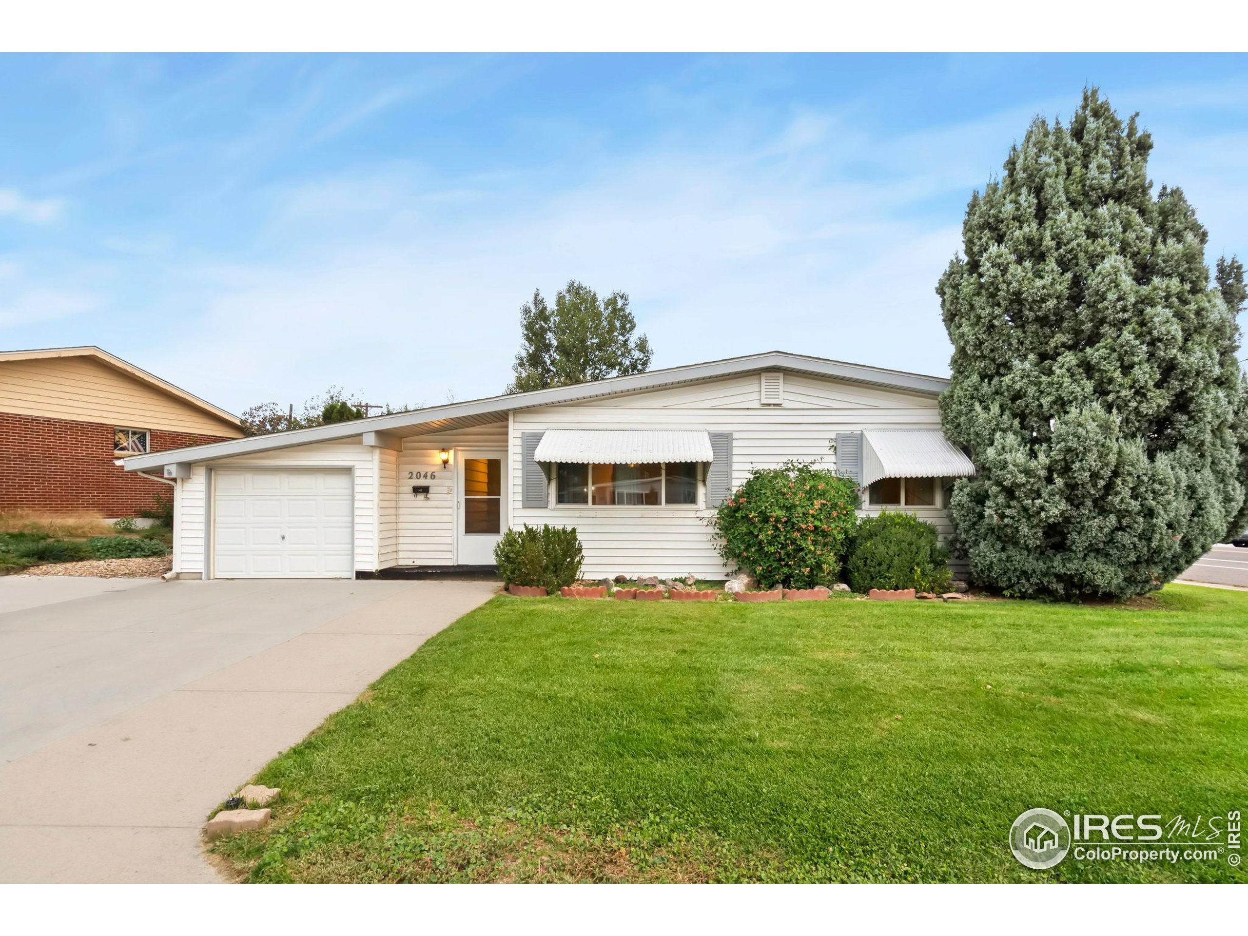 2046 26th Street Road Greeley, CO 80631 - Photo 5 of 34 a front view of a house with a garden and yard