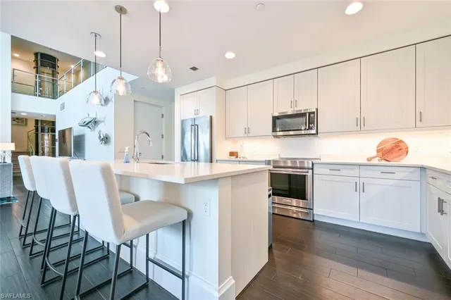 a kitchen with kitchen island granite countertop a sink cabinets and stainless steel appliances