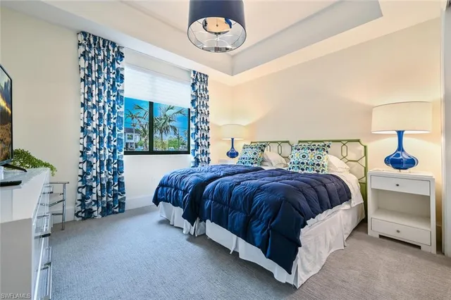 a spacious bedroom with a bed and a chandelier