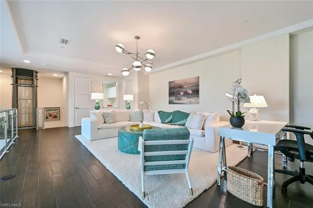 a living room with furniture and a chandelier