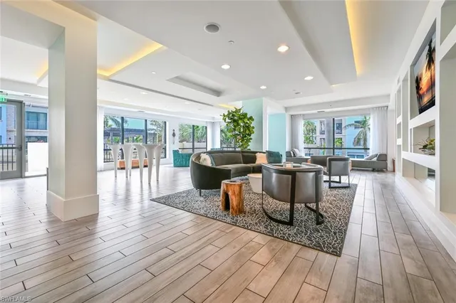 a living room with furniture a wooden floor and a large window