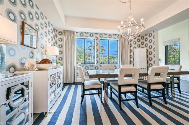 a view of a dining room with furniture a chandelier and wooden floor
