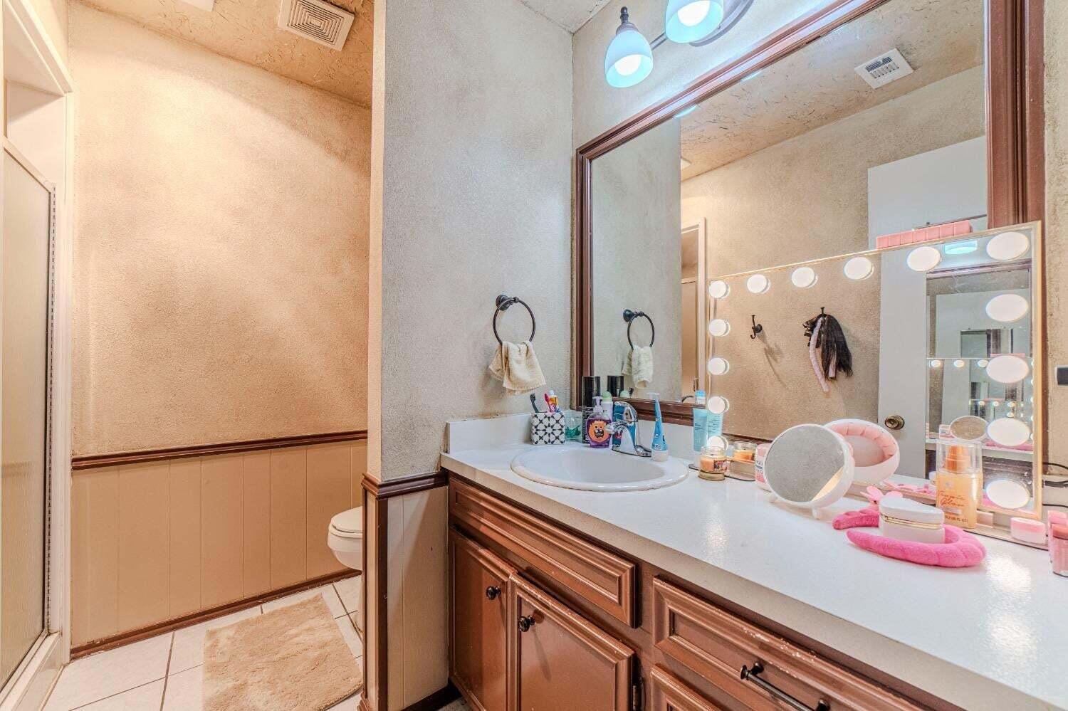 6015 14th Street Lubbock, TX 79416 - Photo 14 of 24 a bathroom with a sink and mirror