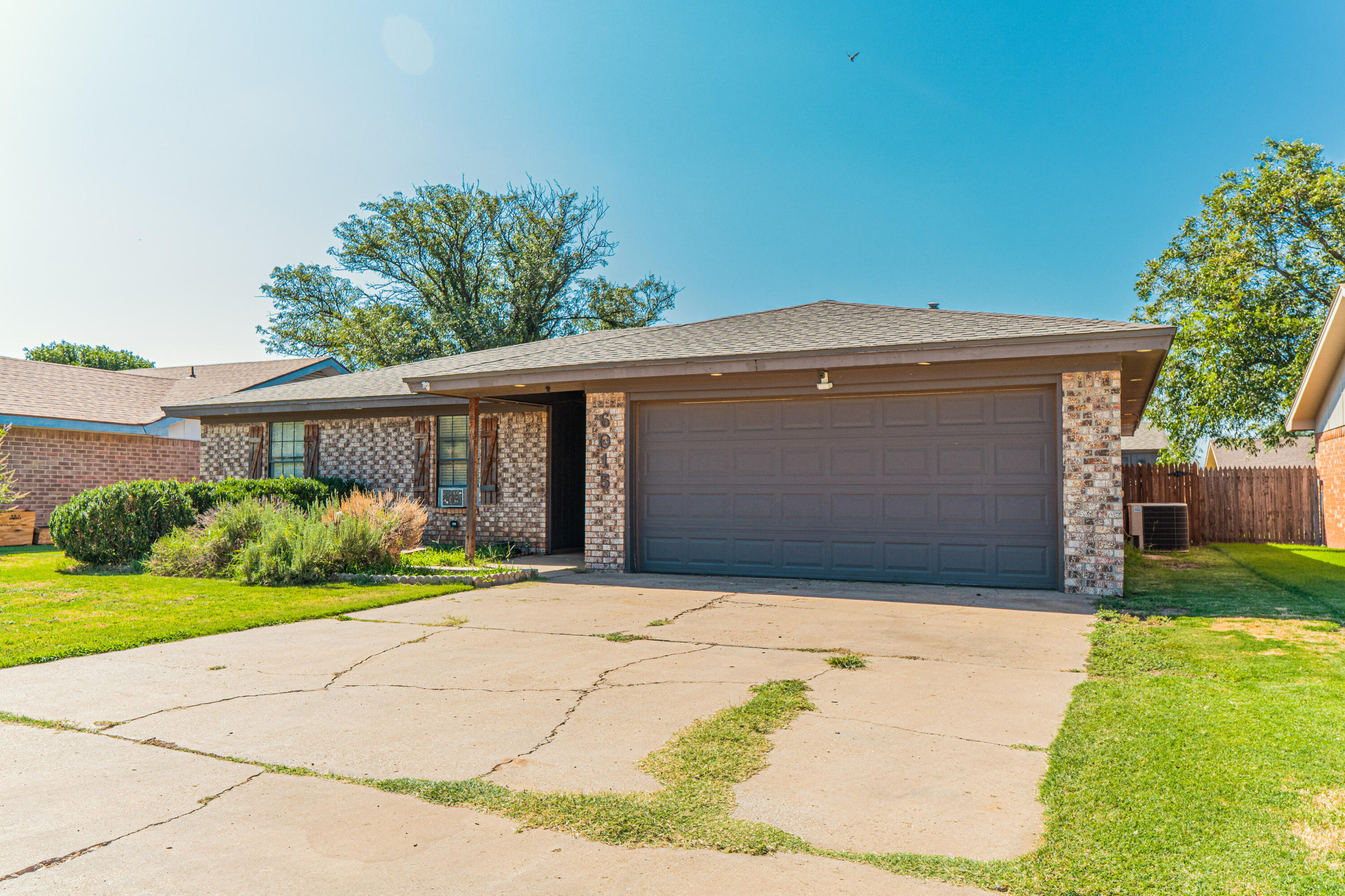 6015 14th Street Lubbock, TX 79416 - Photo 2 of 24 a front view of a house with a yard and garage