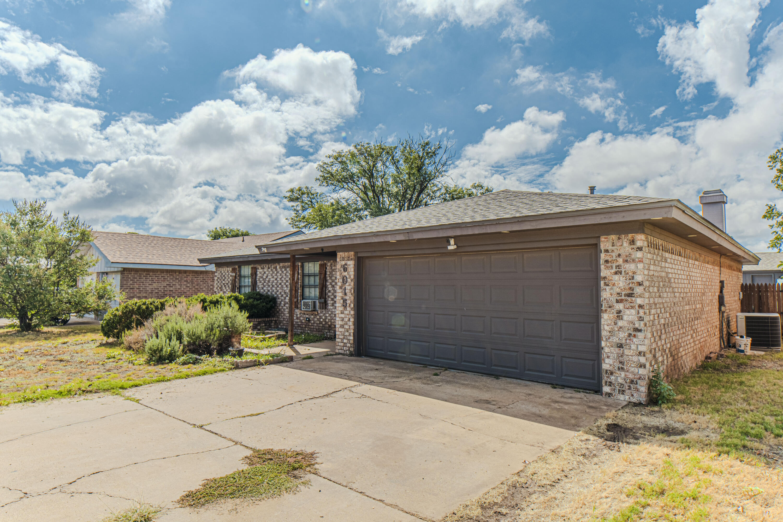 6015 14th Street Lubbock, TX 79416 - Photo 3 of 24 a front view of a house with a yard and garage