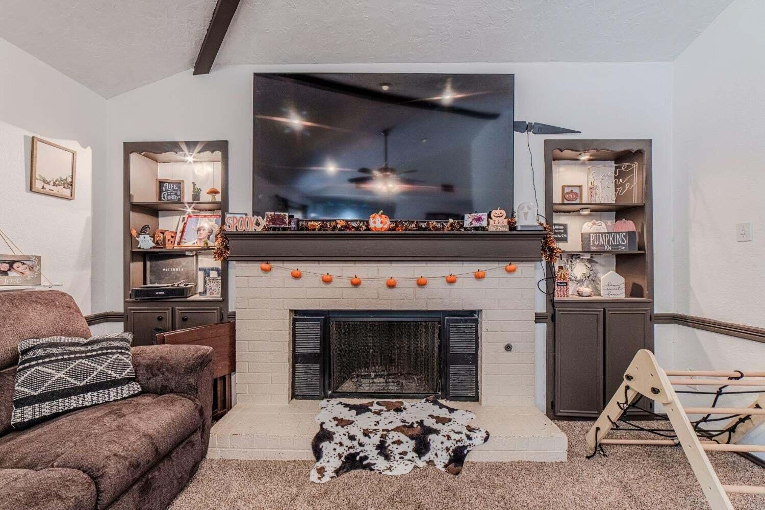 6015 14th Street Lubbock, TX 79416 - Photo 8 of 24 a living room with furniture and a fireplace