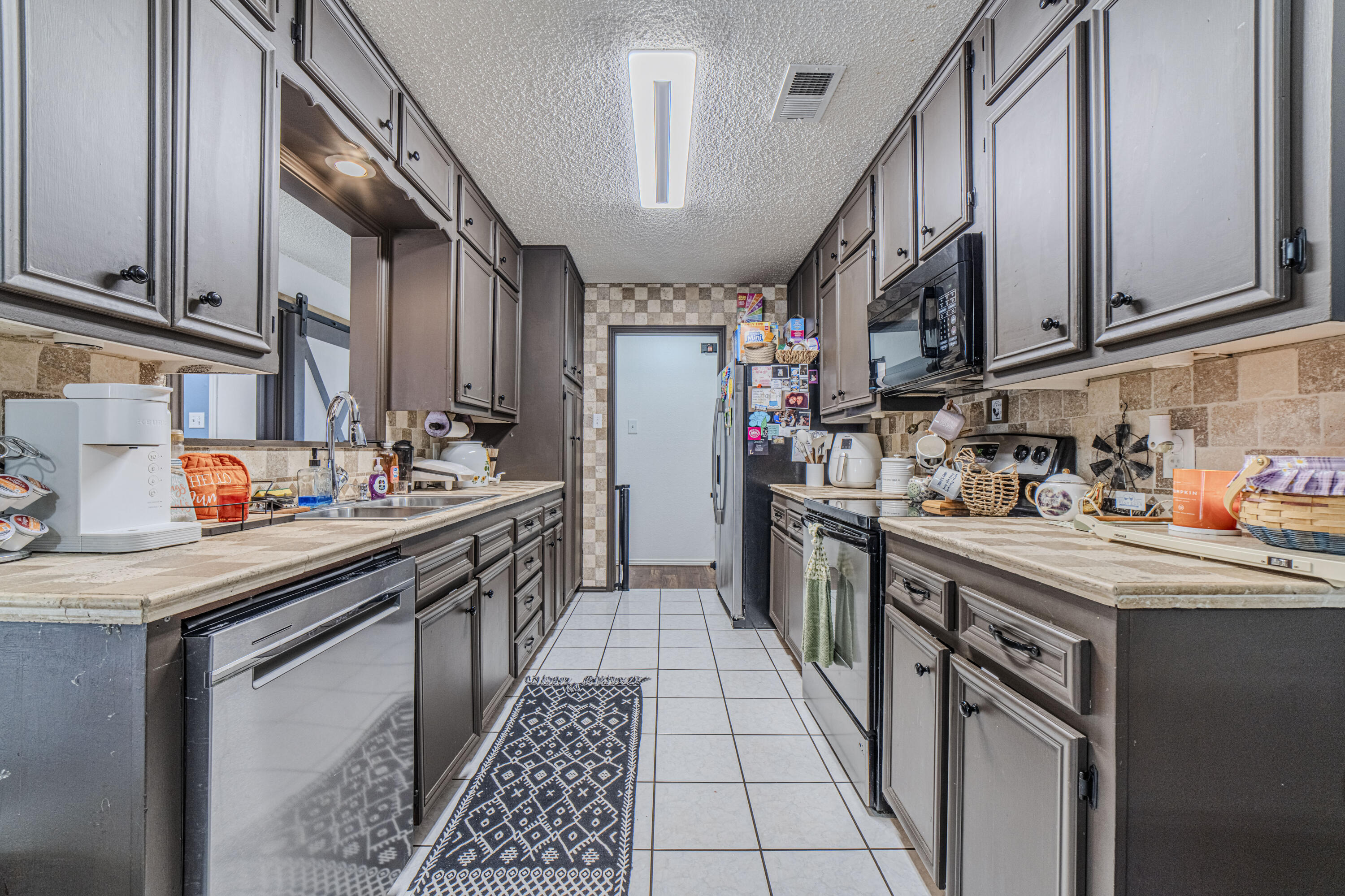 6015 14th Street Lubbock, TX 79416 - Photo 9 of 24 a kitchen with stainless steel appliances granite countertop a sink a stove and cabinets