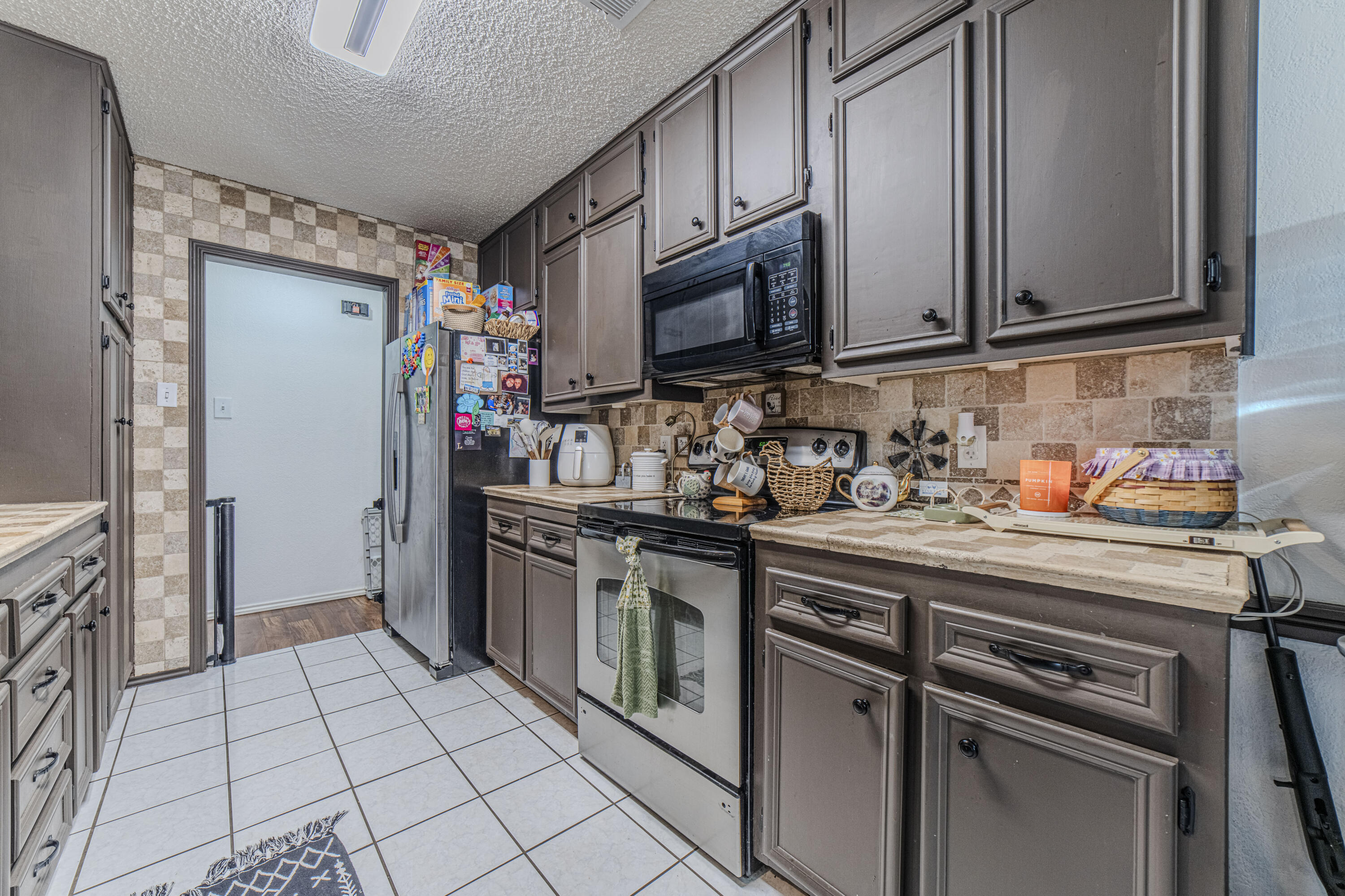 6015 14th Street Lubbock, TX 79416 - Photo 10 of 24 a kitchen with stainless steel appliances granite countertop a refrigerator and a sink